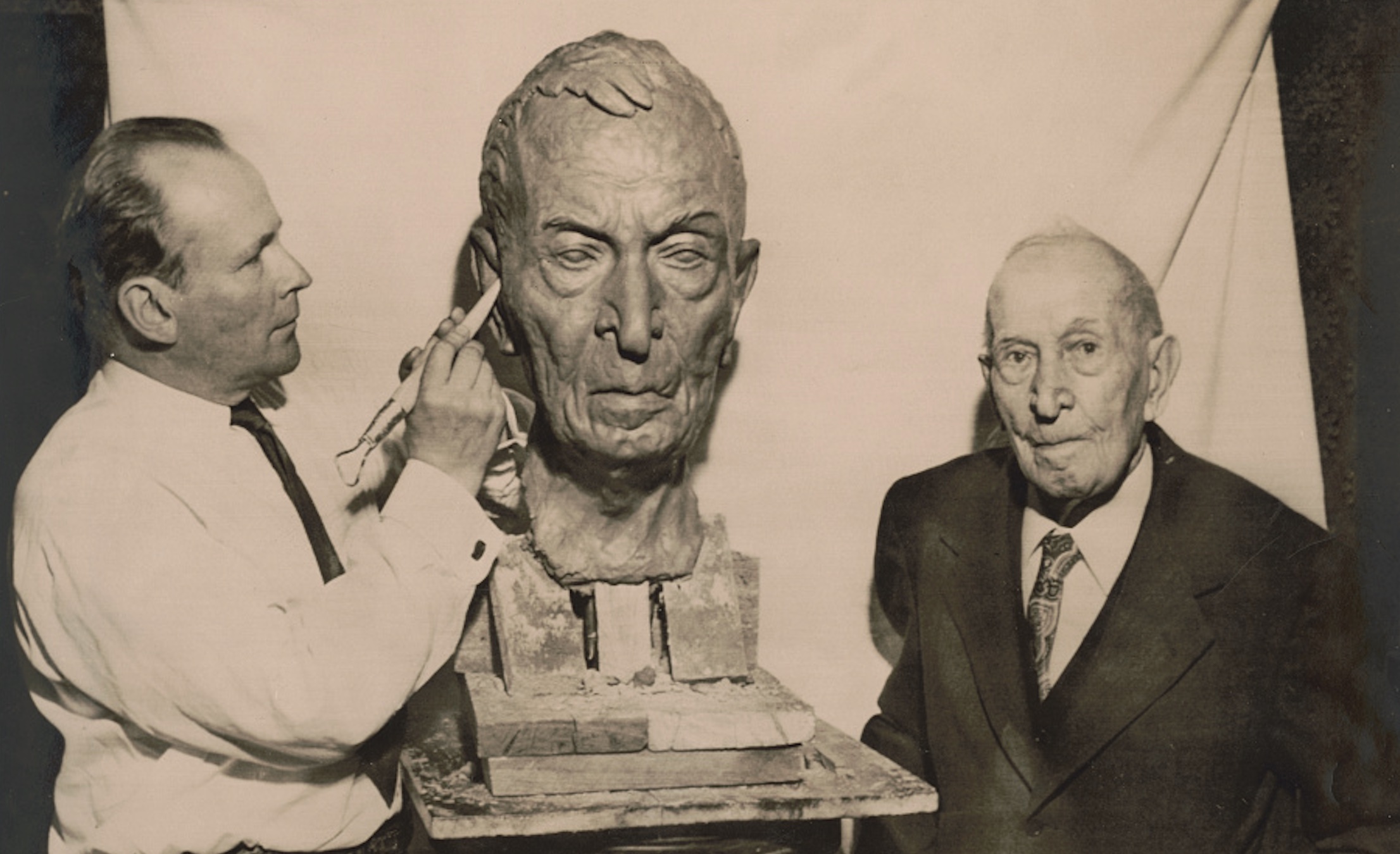 Union veteran Albert Woolson, a former drummer boy of Co. C, 1st Minnesota Heavy Artillery, stands beside an artist making his bust sculpture, which was used to create a Grand Army of the Republic memorial at Gettysburg in Ziegler's Grove.