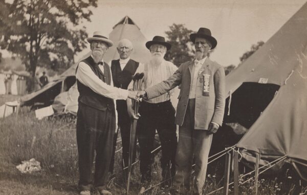 Union and Confederate veterans shake hands at a veterans’ encampment held early in the 20th century.